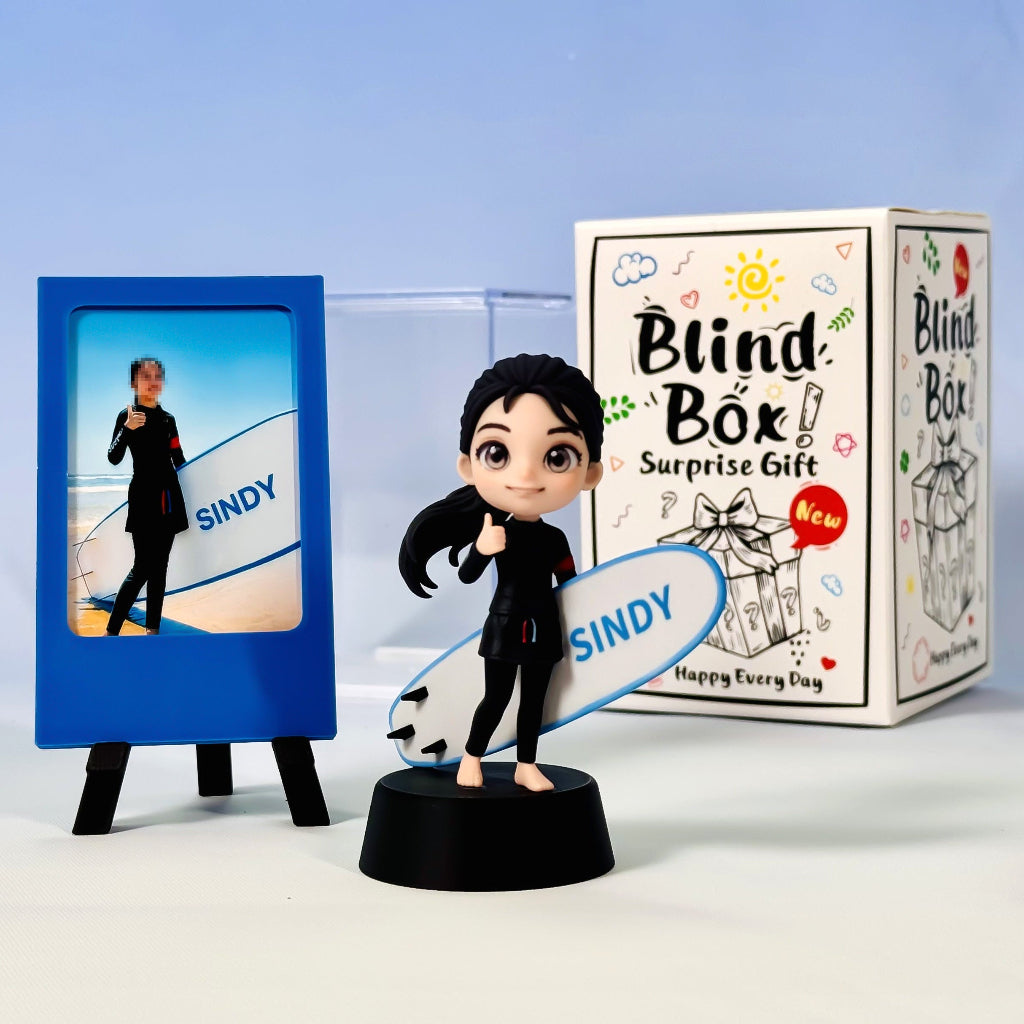Finished surfer figure with a white surfboard beside a blue photo frame and illustrated box