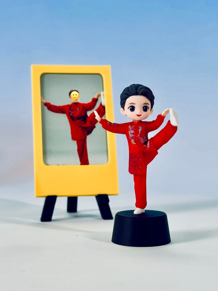 Finished red custom Tai Chi figure in a one-leg pose beside a yellow simple photo frame