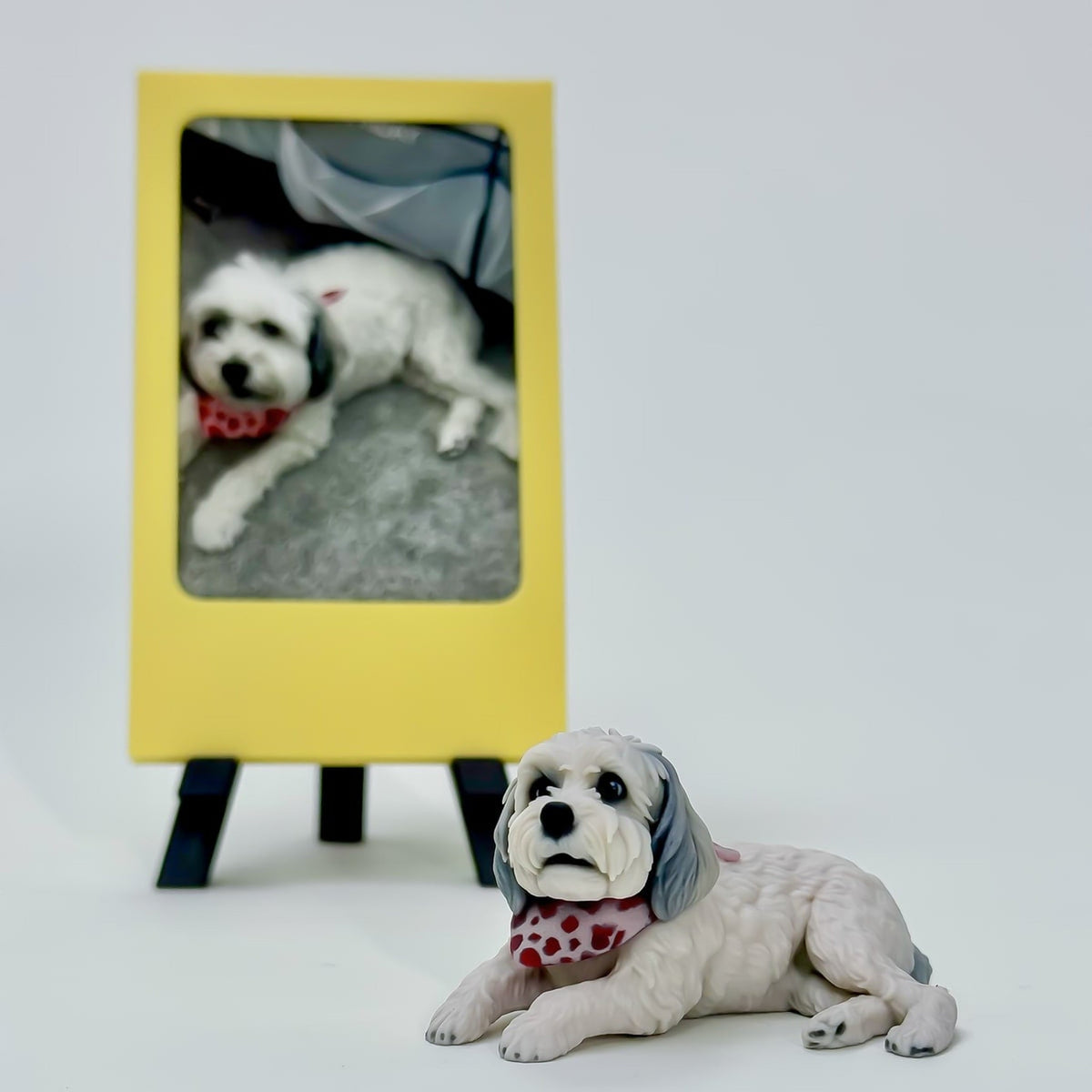 Finished custom full-color dog figurine of Tashi beside the original pet photo