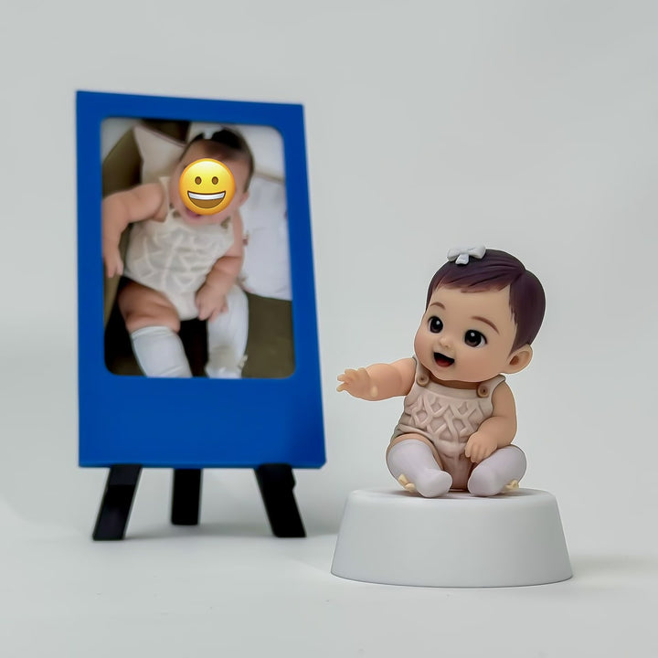 Finished full-color seated baby figure displayed beside a simple blue photo frame